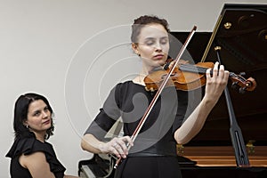 Musicians of the symphony orchestra. Young violinist and pianist in concert dresses