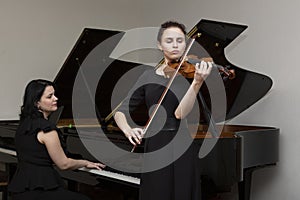 Musicians of the symphony orchestra. Young violinist and pianist in concert dresses