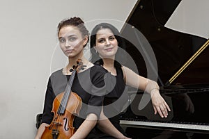 Musicians of the symphony orchestra. Young violinist and pianist in concert dresses