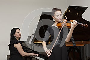 Musicians of the symphony orchestra. Young violinist and pianist in concert dresses