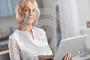 Musing mature woman studying online