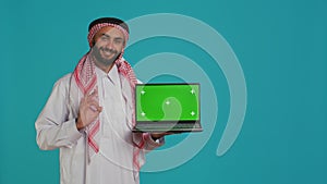 Muslim adult shows greenscreen laptop