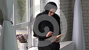 Muslim arabic female reading book at home