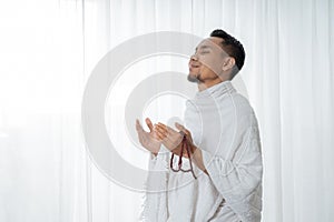 Muslim asian man praying with prayer beads