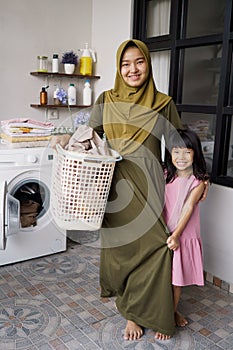 muslim asian mother and child girl little helper in laundry room