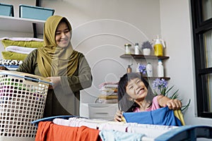 muslim asian mother and child girl little helper in laundry room