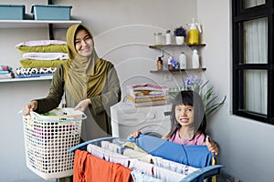 muslim asian mother and child girl little helper in laundry room