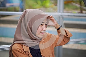 muslim asian woman with hand on head pose