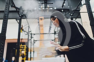 Muslim asian woman in hijab exercizing in a gym.