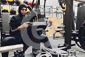 Muslim asian woman in hijab exercizing in a gym.