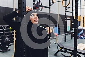 Muslim asian woman in hijab exercizing in a gym.