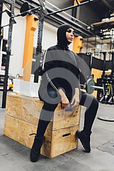 Muslim asian woman in hijab exercizing in a gym.