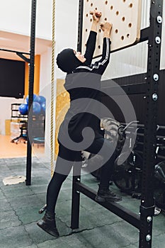 Muslim asian woman in hijab exercizing in a gym.