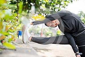 muslim asian woman strecth her leg during sport time outdoor