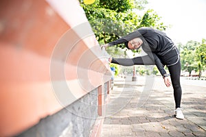 muslim asian woman strecth her leg during sport time outdoor