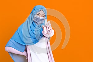 Muslim Asian woman with traditional dress wearing medical face mask