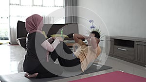 muslim beautiful woman and husband doing sit up together