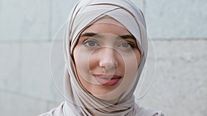 Muslim beauty. Close up portrait of young gorgeous middle-eastern woman wearing hijab smiling to camera outdoors