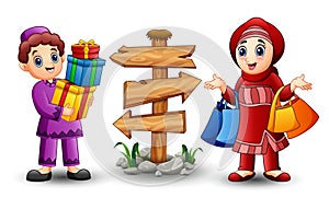 Muslim boy cartoon holding gift box with muslim girl holding shopping bag