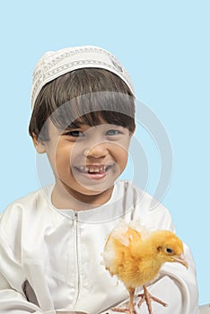 Muslim  boy in a dress and A chick , isolate background