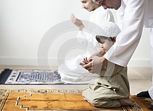 Muslim boy learning how to make Dua to Allah