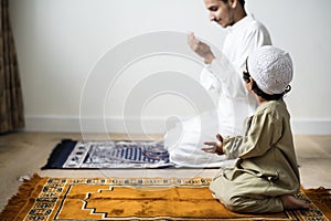 Muslim boy learning how to make Dua to Allah photo