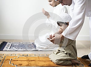 Muslim boy learning how to make Dua to Allah photo