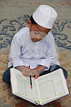 Muslim boy reading Quran