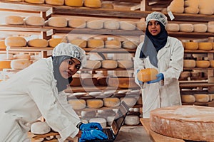 Muslim business partners checking the quality of cheese in the modern industry