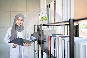 Muslim Business Woman in Hijab with Documents at Workplace in Office