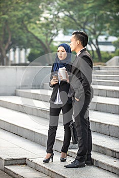 Muslim Businessman and Businesswoman having a conversation during a coffee break. Outdoor scene