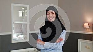 Muslim businesswoman in hijab, friendly gaze in hotel room Middle Eastern Face.