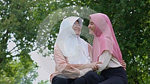 Muslim careful caregiver or nurse taking care of the patient in the hospital park. Happy Muslim mother in hijab hugging daughter.