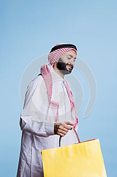 Muslim consumer carrying shopping bag