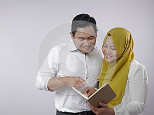 Muslim Couple Analyzing Financial Management Report