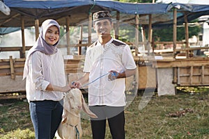 Muslim couple buy a goat for eid adha sacrifice or idul qurban