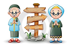 Muslim couple greeting cartoon with blank wood arrow sign