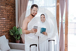 Muslim couple making a phone call while umrah and hajj photo