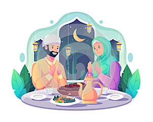 Muslim couple praying before having iftar after fasting during Ramadan Kareem Mubarak. food and dates on the table