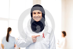 Muslim doctor in hijab with red awareness ribbon