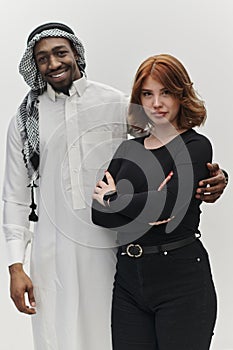 Muslim entrepreneur and a contemporary red-haired girl strike a pose together against a clean white background