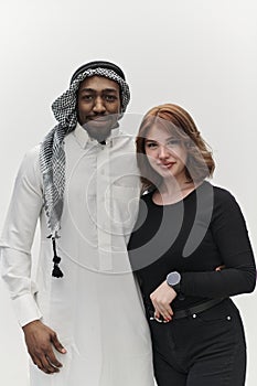 Muslim entrepreneur and a contemporary red-haired girl strike a pose together against a clean white background