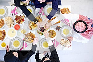 Muslim family having Iftar dinner eating dates to break feast top view