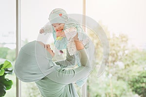 Muslim family or Islam mother with her healthy baby happiness playing together at lovely home. single mom