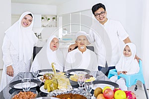 Muslim family looking at camera together at home