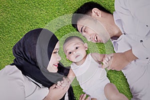 Muslim family lying down on grass