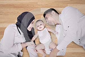 Muslim family lying on the wooden floor