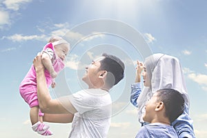 Muslim family playing outside with baby