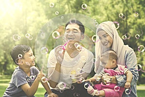 Muslim family playing with soap bubble