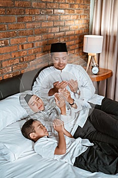 Muslim family pray on the bed